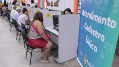 Pessoas de baixa renda sendo atendidas num Centro de Referência de Assistência Social (Cras) em Manaus, onde se vê uma grande faixa que diz "Atendimento Cadastro Único"