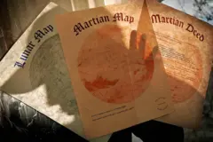 Três papéis com o mapa de imóveis da Lua, de Marte e a escritura de um terreno em Marte