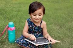 పలకపై అక్షరాలు దిద్దుతున్న చిన్నారి