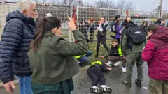 Okupljeni oko povređene devojke tokom protesta na Novom Beogradu