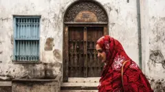 በስቶን ታውን እየተራመደች ያለች ግለሰብ 