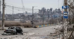 Foto de 2022 mostra a cidade ucraniana de Mariupol, ocupada pela Rússia, em ruínas, com um carro queimado entre os destroços em uma rua deserta