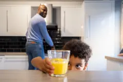 Enfant avec une tasse de jus d'orange