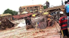 aworan ẹkun omi to n wọ ọpọ mọto lọ, to si bo ọpọ ile mọlẹ, awọn eeyan kan duro sori orule ile wọn