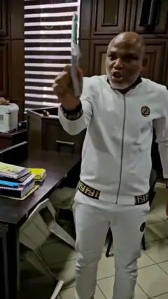 Visibly angry Nnamdi Kanu pointing a book
