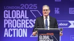 「グローバル・プログレス・アクション」と書かれた青いパネルを背に、演壇に立って演説するキア・スターマー英首相。演壇にも同じ文言が書かれている