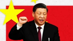 演説する習主席と中国国旗