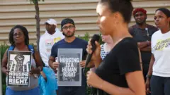 Pessoas com cartazes se manifestam em favor ao direito à moradia