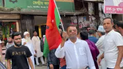বিএনপি পার্টি অফিসের সামনে দলের পতাকা হাতে একজন কর্মী