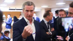 El gobernador Gavin Newsom habla ante reporteros en un salón de DAvos