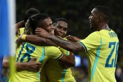Jogadores da Seleção Brasileira se abraçando após gol durante amistoso.