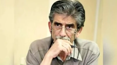 در عکس یونس تراکمه عینک به چشم دارد و یک خودنویس در دست دارد، دستش را روی لب‌هاش گذاشته و به نظر می‌رسد مشغول گوش دادن است. 