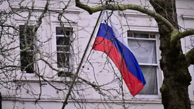 Rosyjska flaga widoczna za drzewami
