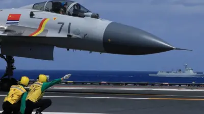 Crew members and a J15 fighter jet are seen on the flight deck on the aircraft carrier Liaoning during a drill on Apirl 9, 2021 in South China Sea.