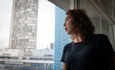 Maira na janela de seu apartamento no Copan olha a paisagem