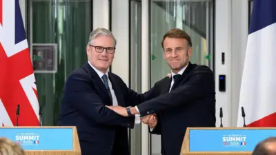 UK Prime Minister Sir Keir Starmer and French President Emmanuel Macron shake hands during a press conference.