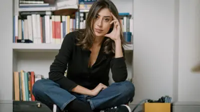 Cecilia Sala, evinde kamerelara yerde bağdaş kurmuş bir şekilde oturarak poz veriyor