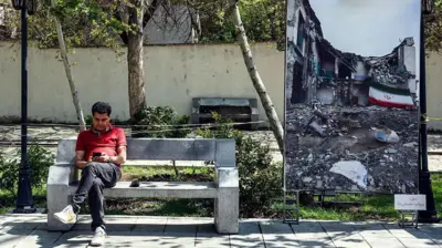 یک مرد ایرانی هنگام نشستن روی نیمکتی و نگاه کردن به تلفن همراهش، در کنار یک عکس بزرگ که «جنگ کنونی خاورمیانه» را نشان می‌دهد، در پارکی در تهران دیده می‌شود؛ این تصویر در ۱۶ آوریل ۲۰۲۶ (۲۷ فروردین ۱۴۰۵) ثبت شده است. قطع اینترنت که اندکی پس از حمله آمریکا و اسرائیل به ایران در ۲۸ فوریه ۲۰۲۶ (۹ اسفند ۱۴۰۴) اعمال شد، طبق گزارش نت‌بلاکس تا ۵ آوریل (۱۶ فروردین ۱۴۰۵) طولانی‌ترین قطعی سراسری ثبت‌شده در کشور بوده و اکنون بیش از ۵۰ روز ادامه یافته است. اینترانت بسیار محدود داخلی ایران در طول جنگ فعال بوده و به مردم امکان اتصال به وب‌سایت‌های داخلی را می‌دهد، اما همچنان برای فعالیت عادی کسب‌وکارها در کشوری که اقتصاد آن پیش‌تر نیز تحت تأثیر تحریم‌های بین‌المللی تضعیف شده، کافی نیست.