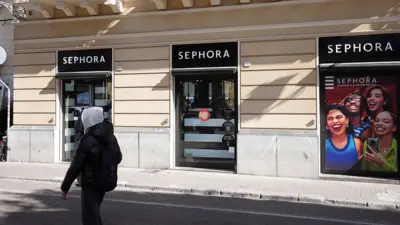 İtalya'nın Palermo kentinde, bir Sephora mağazası ve onun önünden geçen kafasında kapşon olan bir kişi.