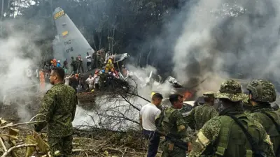 This screen grab shows soldiers and rescuers near an Air Force Hercules emitting thick smoke after the aircraft crashed during takeoff in Puerto Leguizamo, Colombia, near the southern border with Ecuador, on March 23, 2026.
