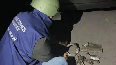 Сотрудник прокуратуры осматривает остатки реактивного КАБа, которым РФ нанесла удар по городу Лозовая в Харьковской области 18 октября.