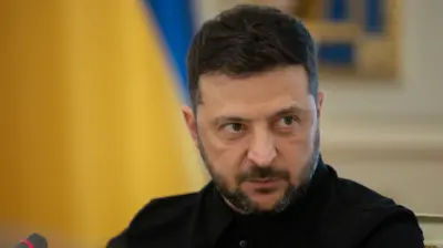 Володимир Зеленський дивиться в камеру на тлі розмитого прапора України