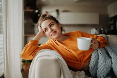 Mulher com xícara de chá na mão sorrindo