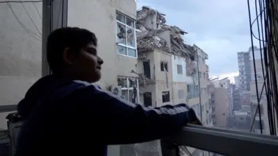 boy looks out over Tyre destruction