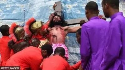 Aworan awọn eeyan dudu to n se ere bi wọn se kan Jesu mọ agbelebu, ọkunrin alawọ dudu naa ni wọn kan mọ igi agbelebu