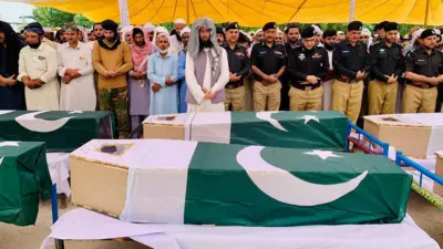 د جنازې مراسمو په دغه عکس کې ګڼ تابوتونه ایښي چې د پاکستان بیرغ پرې اچول شوی او شا ته یې ملا او ورپسې مقتدیانو د جنازې لمونځ ته اقتدا کړې ده.