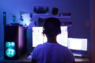Menino em frente a um computador, usando headphones