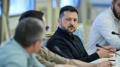 Зеленський сидить за столом з журналістами