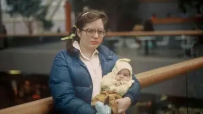 Patricia Lynn Lane trzyma na rękach swoją córkę, podczas gdy jej mąż, Mark Timothy Gurney, robi jej zdjęcie.