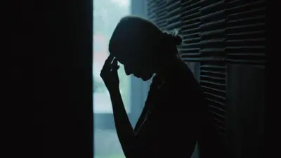 تصویری تیره از دختری که دستش را روی سرش گذاشته است