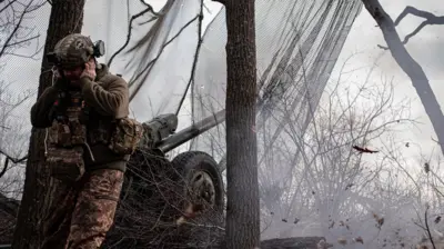 Військовий стріляє з гармати