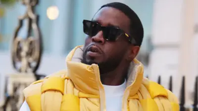 Sean Combs aka Diddy looks on wearing black sunglasses and yellow puffer jacket while out and about on November 10, 2023 in London, United Kingdom