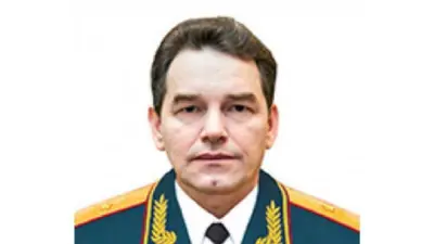 Imagen de Fanil Sarvarov. En la fotografía viste su uniforme militar y mira hacia la cámara con rostro serio. El uniforme militar es verde, amarillo y rojo. Lleva camisa blanca y corbata negra. El fondo de la imagen es blanco. 