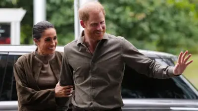 Prens Harry ve Meghan, 14 Nisan 2026'da Avustralya'nın Melbourne şehrindeki Avustralya Ulusal Gaziler Sanat Müzesi'ne vardıklarında el sallıyorlar.