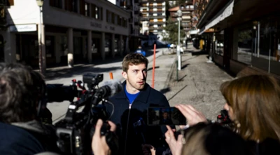 Halktan biri kendisine çevrilmiş kameralara konuşuyor, arkada olayın yaşanddığı barın uzaktan görüntüsü var.