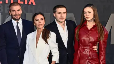 David, Victoria, Brooklyn Beckham y Nicola Peltz posando en una alfombra roja