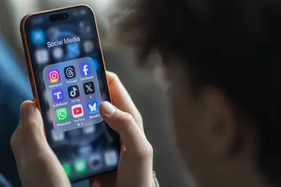 Cep telefonundaki sosyal medya uygulamalarına bakan bir erkek çocuğu