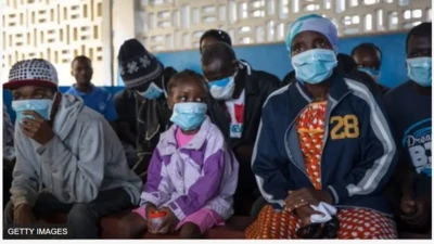 Aworan awọn eeyan to lo ibomu, ti wọn jokoo tẹle ara wọn