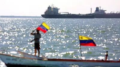 Un pescador ondea la bandera venezolana en su embarcación frente al petrolero Pilín León, amarrado el 18 de diciembre de 2002 en Maracaibo, Venezuela. 
