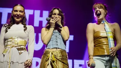 Remember Monday smile and laugh on stage as they get a warmer-than-anticipated welcome from Eurovision fans. Holly-Anne, in the centre, clasps her hands over her mouth in surprise.