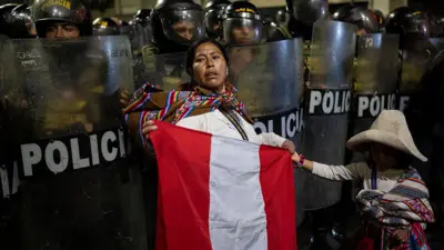 Una mujer protesta ante la policía.