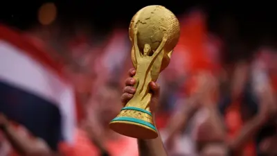 Simpatizante alza una réplica de la copa en medio de la tribuna