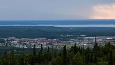 湖と木々に囲まれた建物を遠方から撮影した写真