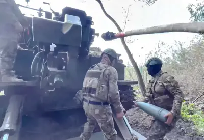 Два российских артиллериста заряжают гаубицу