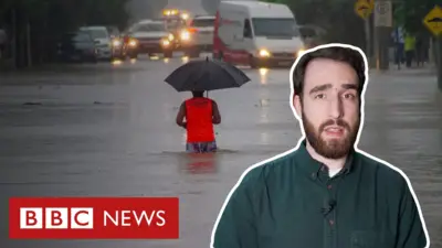 Imagem de repórter em frente a foto de inundação 