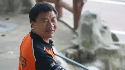 身穿橙色Polo恤的王计兵面带笑容望向镜头。